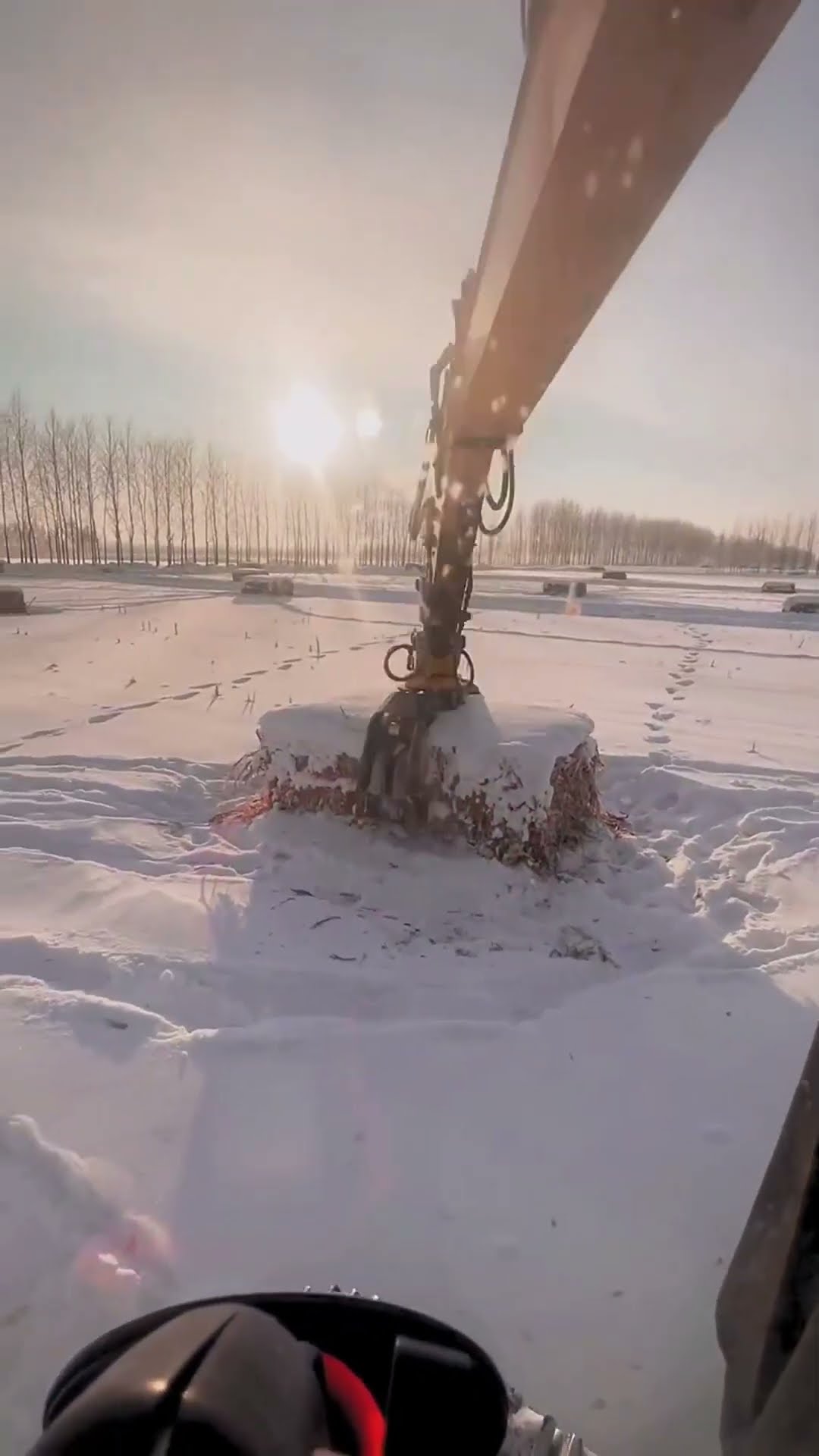 The process of grabbing grass bales in the snow- Good tools and machinery make work easy