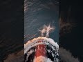 Bottlenose Dolphins Lead Large Ship While Bow Riding in Deep Ocean