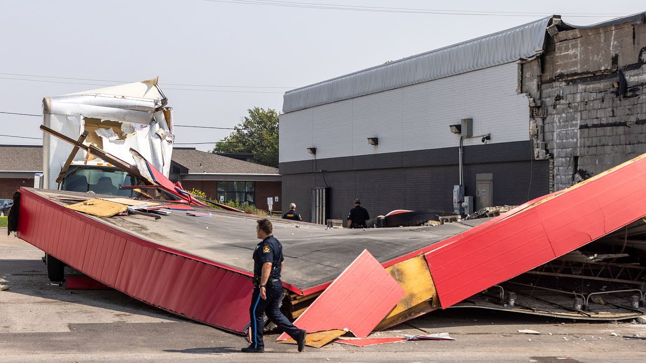 Truck collides with drive-through awning, trapping driver - YouTube