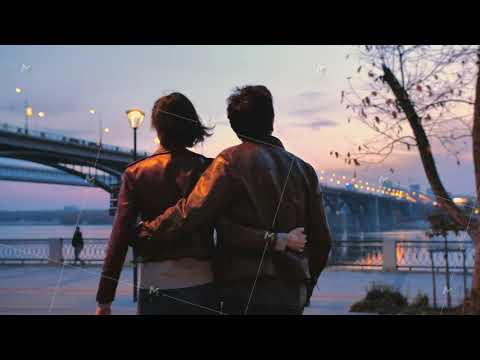 Rear view of a young couple holding hands walking together in the park against the backdrop of