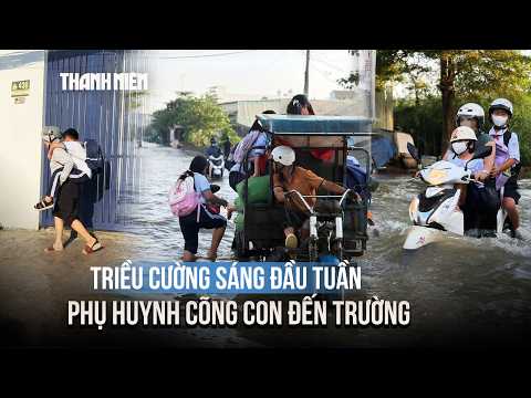 Tidal flooding hits half a meter in HCMC, parents wade through water to carry children to school