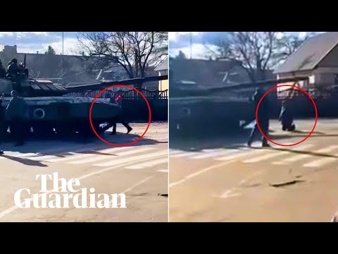 Ukrainian resistance: man climbs on to Russian tank then kneels before it