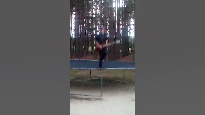 A boy, a trampoline and his guitar