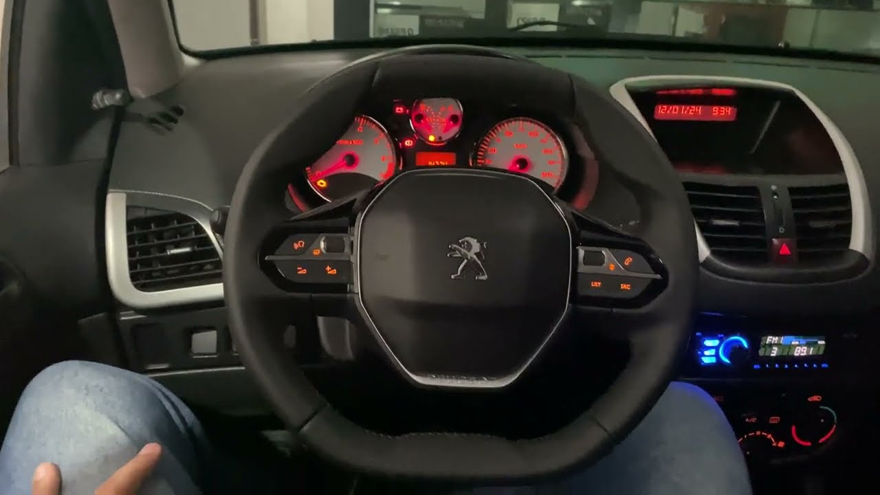 Peugeot 207 com volante multifuncional instalado no sistema original 