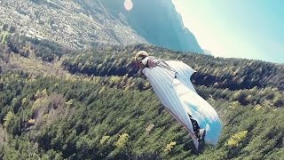 مغامر يحلق في منطقة جبال الألب مرتديا بزة للطيران