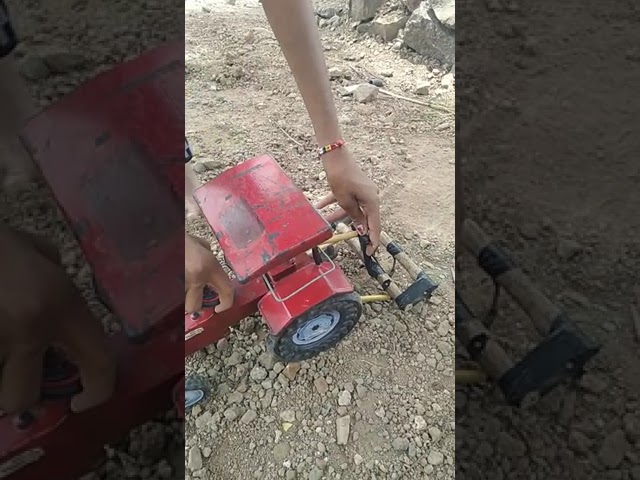 Mahindra tractor toy on small farm class=