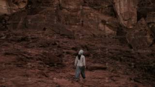 young woman walking in desert in the evening, after sunset