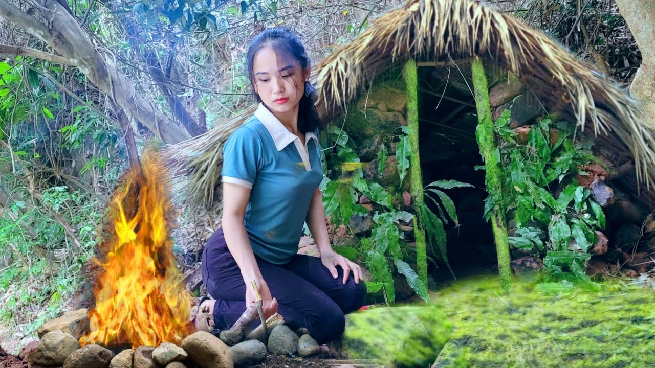 Solo bushcraft. The girl builds shelter with rocks and handmade animal ...