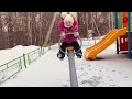 Alisa plays on the playground with mom on a winter day