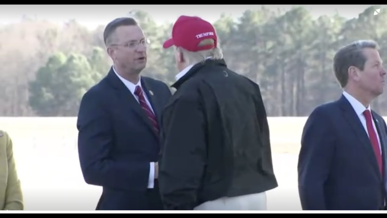 Trump shakes hands with Rep. Doug Collins, now being self-quarantined