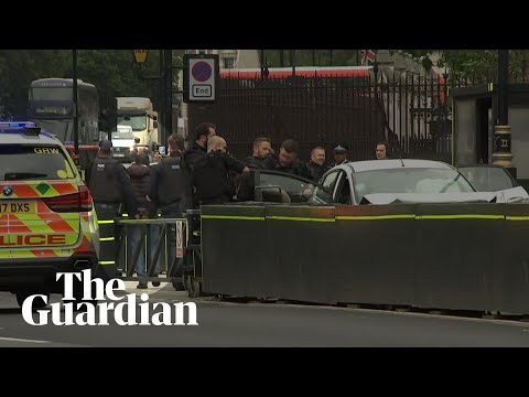 Westminster car crash: handcuffed man taken away by police