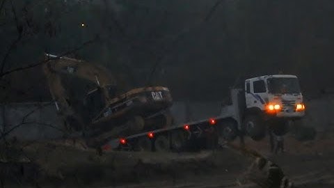 Big Excavator Unloading Off Trailer