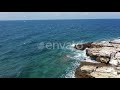 Waves Crashing on Rocky Coastline on Sunny Day
