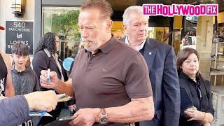 Arnold Schwarzenegger Smokes A Cigar While Signing Autographs For Fans While Leaving His Hotel In NY