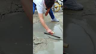 Repairing damaged and uneven road surfaces in front of the warehouse using strong liquid cement.