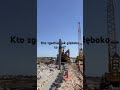 Potężna maszyna wbija stalową ramę w błotnistą transzeję | Prace fundamentowe na budowie