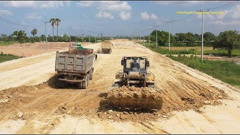 Wheel loader digging loading dump trucks - dirty soil out road