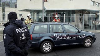 Car daubed with anti-globalisation message crashes into gate of Angela Merkel's Berlin office