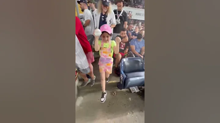 Aaron Barnett giving a young fan her first basebal...