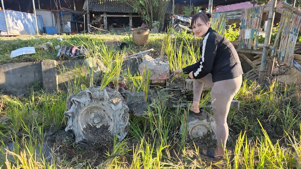 The girl repairs, restores and cleans the entire broken tractor engine in the field.