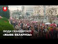 Многотысячная колонна людей подходит к Октябрьской площади