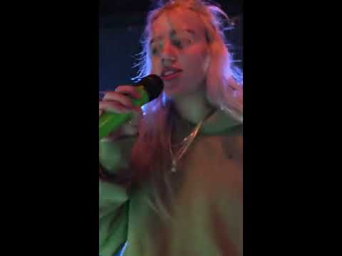 Billie Eilish gives water to a fan who's about to pass out during Ocean Eyes