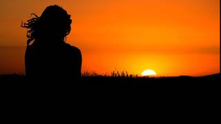 Video Background Stock Footage Free ( A female silhouette looks at the horizon where the sun sets )