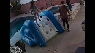 Family stands around pool then girl jumps on ledge and slips into jacuzzi/hot tub (Security camera)