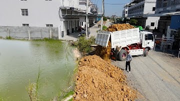 Recently Developed Landfill Up Action Operator Bulldozer Push Soil and Dump Truck Unloading Soil