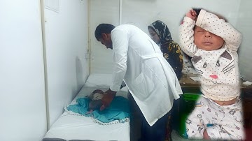 A nomadic mother with her baby in a cradle crosses a difficult path to hospital