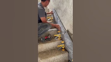 the process of installing ceramic tiles on the side of the stairs to match the theme of the room