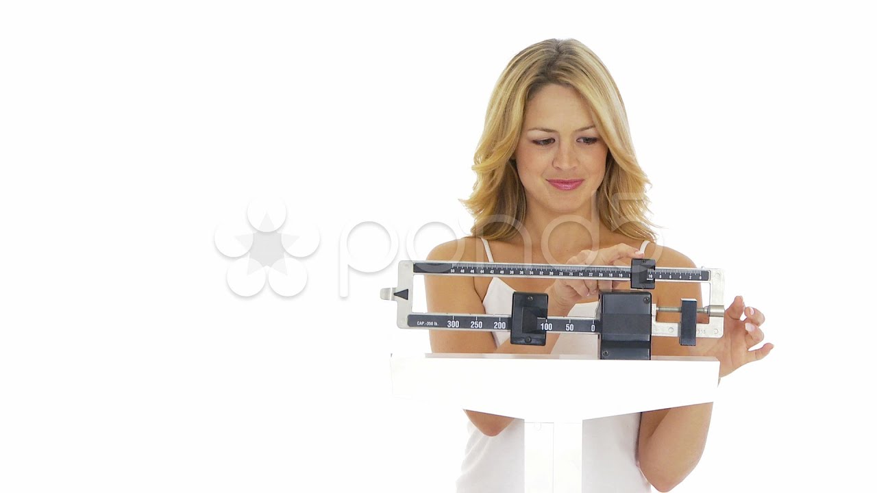 Happy Young Woman Weighing Herself On Scale. Stock Footage