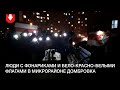 Люди с фонариками и бело-красно-белыми флагами в микрорайоне Домбровка вечером 3 октября
