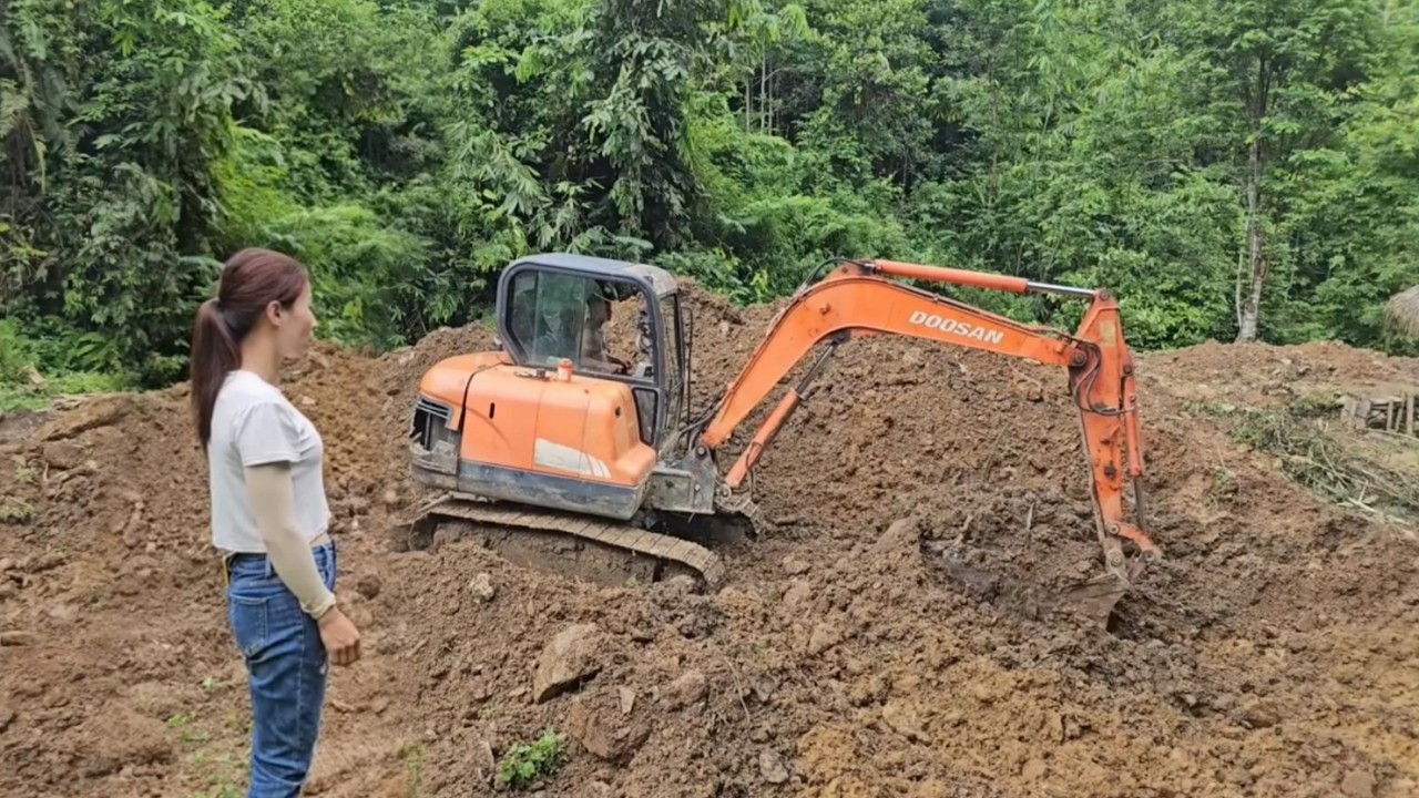 The entire process of the excavator digging the pond during heavy rain.