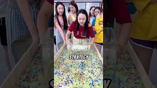 Friends Compete in a Colorful Bead Scooping Challenge for a Prize.