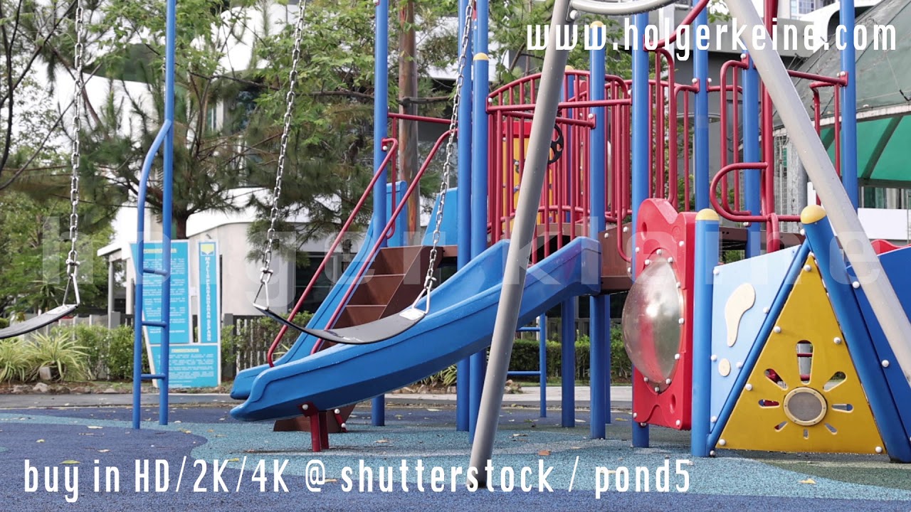 A slow motion footage of an empty, abandoned, swinging swing in a playground