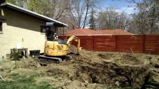 Digging a small foundation hole with a rented excavator