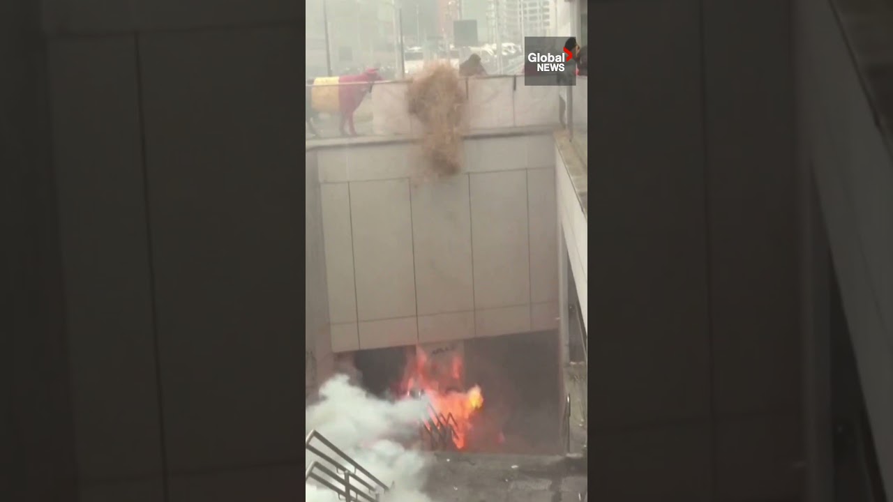 Belgian farmers use manure-spraying tractor to combat police water cannon 