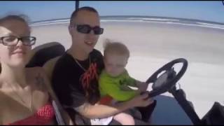 1 year old driving a golf cart on beach