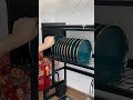 Clean bowls and plates on drainage shelf, water drips to sink for hygiene
