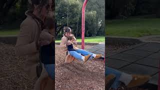 Woman falls back with baby on swing at playground