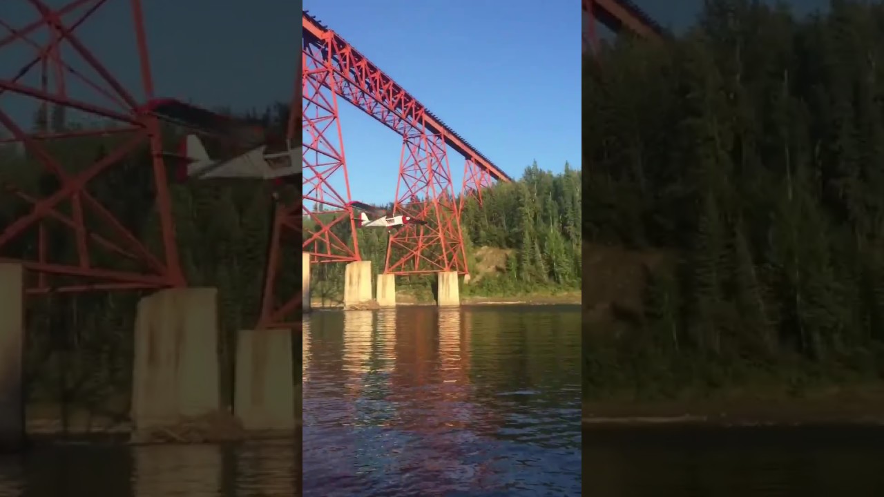 Plane flying under train bridge