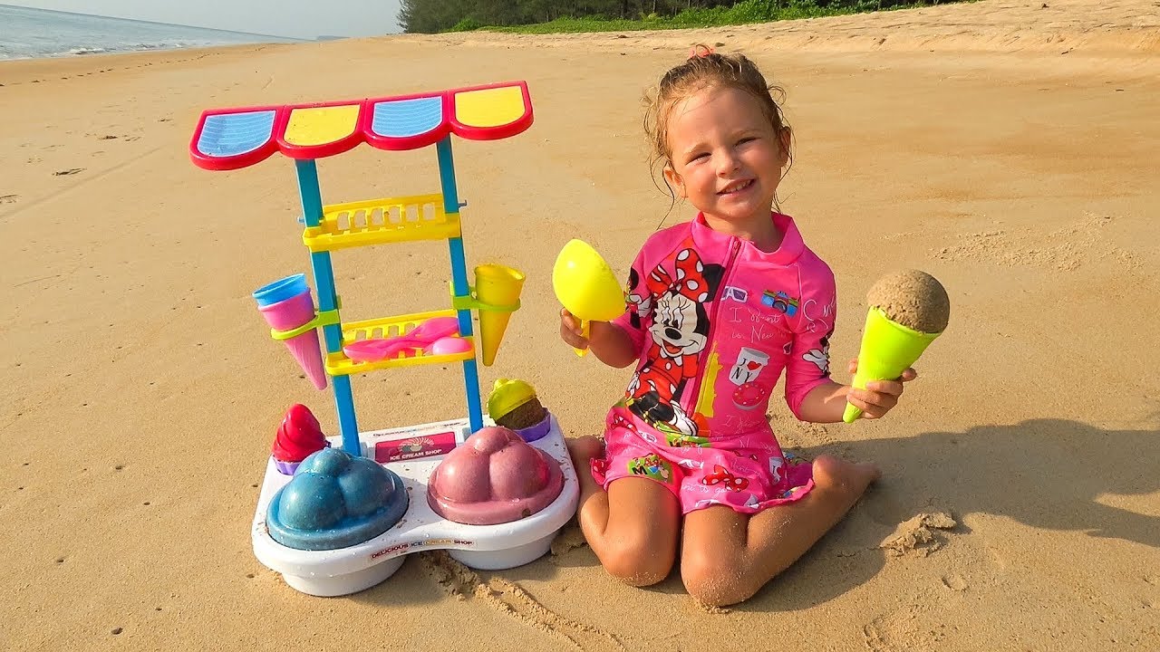 Milusik Lanusik and Dolls Play with colored Ice Cream Toys and cakes from sand on the Beach