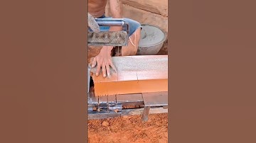 Worker Operating a Manual Press to Cut and Form Clay Bricks