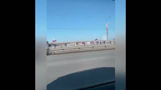 Люди с флагами на мосту