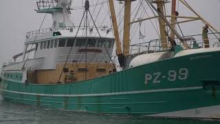 Two big vessels enter Newlyn in poor weather.