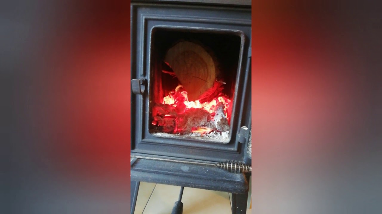 Jotul loading big piece of wood - YouTube