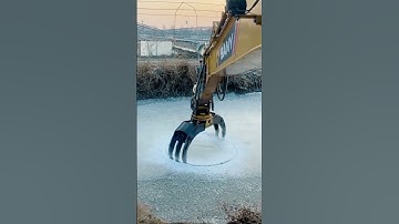the process of drilling holes in the ice layer on the lake using an excavator #shorts