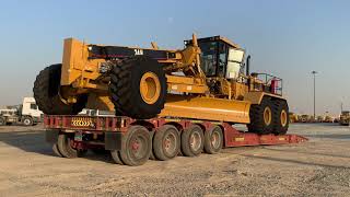 Caterpillar 24H Motor Grader transporting and unload over size machine heavy equipment mega machine.