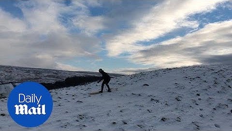 Brave man goes SNOW surfing in Yorkshire as icy weather grips UK - Daily Mail